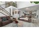 Open-concept living room featuring high ceilings, wood staircase, comfortable seating, and bright decor at 6454 Leathers Ln, Parker, CO 80134