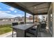 Covered outdoor patio with seating and a view of the backyard and neighborhood at 6454 Leathers Ln, Parker, CO 80134