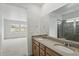 Bathroom featuring double sinks, granite countertops, light wood cabinets, and a large framed mirror at 17156 W 92Nd Loop, Arvada, CO 80007