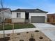 Charming single-Gathering home featuring a stone facade, gray garage door, and well-manicured front yard at 17156 W 92Nd Loop, Arvada, CO 80007