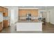 A stylish kitchen featuring wood cabinets, granite countertops, stainless steel appliances, and a large central island at 17156 W 92Nd Loop, Arvada, CO 80007