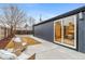 Inviting backyard features a concrete patio with wicker chairs, a well-manicured lawn, and a dark painted exterior at 5523 Tejon St, Denver, CO 80221
