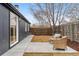 Inviting backyard features a concrete patio with wicker chairs, a well-manicured lawn, and a wooden privacy fence at 5523 Tejon St, Denver, CO 80221