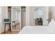 Bedroom featuring a mirrored closet with seating, plush bed, and access to living area at 5523 Tejon St, Denver, CO 80221