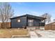 Charming single-story home boasts a covered porch and dark siding at 5523 Tejon St, Denver, CO 80221