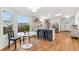 Sunlit kitchen featuring an island with seating, stainless steel fridge, and hardwood floors at 5523 Tejon St, Denver, CO 80221