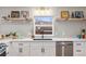 White cabinets and floating shelves add stylish storage to this kitchen at 5523 Tejon St, Denver, CO 80221