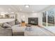 Cozy living room with a gray sectional, fireplace, and sliding glass doors to the backyard at 5523 Tejon St, Denver, CO 80221