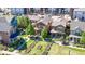 Aerial view showcasing homes with landscaped yards, sidewalks, and a parking lot in a vibrant community at 7932 E 49Th Pl, Denver, CO 80238