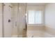 Bright bathroom featuring separate shower and tub with white tile surround and window at 7932 E 49Th Pl, Denver, CO 80238