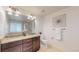 Bright bathroom featuring a dual sink vanity with granite countertop and decorative lighting at 7932 E 49Th Pl, Denver, CO 80238