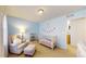 Bedroom with pale blue walls, white crib, a rocking chair and ottoman, and carpeted floor at 7932 E 49Th Pl, Denver, CO 80238