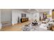 Open living room features hardwood floors, a gray rug, modern furniture, and decorative plants at 7932 E 49Th Pl, Denver, CO 80238