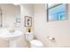 Elegant powder room with a pedestal sink, toilet, and stylish wall decor at 7932 E 49Th Pl, Denver, CO 80238