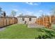 A well-maintained backyard featuring artificial turf, stone exterior, and a secure privacy fence at 3251 N Adams St, Denver, CO 80205