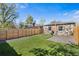 Spacious backyard featuring green artificial turf, stone exterior, and new wooden fence for privacy at 3251 N Adams St, Denver, CO 80205