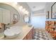 A stylish bathroom with double sinks, round mirrors, modern lighting, and patterned tile flooring at 3639 Pine Meadow Ave, Parker, CO 80138