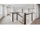 Bright hallway features wood-trimmed railings, and neutral carpeting leading to the upper level at 2464 Wesley Ln, Lafayette, CO 80026
