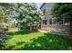 Lush backyard featuring manicured lawn, mature trees, and a charming landscape design at 2675 Timberchase Trl, Highlands Ranch, CO 80126