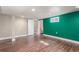 The basement has new wood floors and has a pop of color with the green accent wall at 1350 Valentia St, Denver, CO 80220