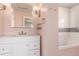 Bathroom features a white vanity with gold fixtures, subway tile backsplash and a soaking tub at 1350 Valentia St, Denver, CO 80220