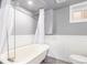 Updated bathroom features a soaking tub, shower, vintage fixtures, and a window for natural light at 1350 Valentia St, Denver, CO 80220