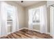 Bedroom with hardwood floors, two windows with white curtains and an air conditioning unit at 1350 Valentia St, Denver, CO 80220