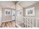 Hallway with hardwood floors, white staircase railing and natural light pouring through the windows at 1350 Valentia St, Denver, CO 80220