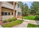 Exterior showing a walkway leading to a condo with manicured lawn and mature trees at 16848 E Gunnison Dr # 9E, Aurora, CO 80017