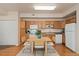 Eat in kitchen with a kitchen table, light wood cabinets, and white appliances at 16848 E Gunnison Dr # 9E, Aurora, CO 80017