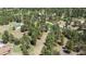 Aerial view of a home with adjacent outbuilding, both with green roofs, set in a dense forest at 33589 Robin Ct, Elizabeth, CO 80107