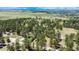 Expansive property featuring a home nestled among mature trees, outlined in white, with rolling hills in the background at 33589 Robin Ct, Elizabeth, CO 80107