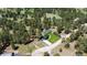 Aerial view of the property, showing the home, surrounding trees, green lawn, and a long driveway at 33589 Robin Ct, Elizabeth, CO 80107