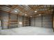 Spacious barn interior featuring a concrete floor, metal walls and ceiling, wooden supports, and built-in shelving at 33589 Robin Ct, Elizabeth, CO 80107