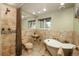 Elegant bathroom featuring a standalone tub, tiled walls, and vintage-inspired fixtures offering a luxurious feel at 33589 Robin Ct, Elizabeth, CO 80107