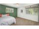 This carpeted bedroom has two windows and a fun splash of green on one wall at 33589 Robin Ct, Elizabeth, CO 80107
