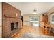 Cozy dining area featuring a brick fireplace, wood floors, and a sliding glass door to the outdoor deck at 33589 Robin Ct, Elizabeth, CO 80107