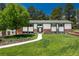 Charming ranch-style home features a lush front yard with mature trees and walkway leading to the front door at 33589 Robin Ct, Elizabeth, CO 80107