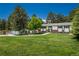 Ranch-style home on sprawling lawn with mature trees offers serene views and ample space for outdoor activities at 33589 Robin Ct, Elizabeth, CO 80107