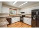 White kitchen featuring wood floors, black appliances, and ample counter space for food preparation at 33589 Robin Ct, Elizabeth, CO 80107