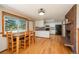 Bright eat-in kitchen featuring white cabinets, black appliances, wood floors and a brick fireplace at 33589 Robin Ct, Elizabeth, CO 80107