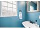 Cozy bathroom with a sink, framed mirror, and blue walls at 1271 Braewood Ave, Highlands Ranch, CO 80129