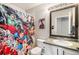 A full bathroom featuring a shower with colorful superhero-themed curtain, single sink, and vanity at 1271 Braewood Ave, Highlands Ranch, CO 80129