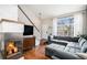 Open living room with stone fireplace, hardwood floors, a large sofa, and lots of natural light at 1271 Braewood Ave, Highlands Ranch, CO 80129