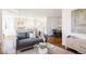 Bright living room features gray sofa, wood floors, and kitchen view at 5095 Umatilla St, Denver, CO 80221