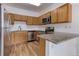 Galley kitchen featuring granite counters, stainless steel appliances, and wood cabinets at 3261 S Waco Ct # K, Aurora, CO 80013