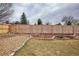 Backyard with a stone lined garden feature and a tall, wooden privacy fence at 9510 Flower St, Broomfield, CO 80021