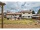 Backyard featuring a spacious lawn, patio pergola, garden beds, and privacy fence at 9510 Flower St, Broomfield, CO 80021