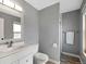 Bright bathroom with white vanity, toilet, and a view into the shower at 9510 Flower St, Broomfield, CO 80021