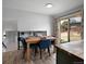 Modern dining area with blue chairs, wooden table and light fixtures, adjacent to sliding doors and kitchen at 9510 Flower St, Broomfield, CO 80021